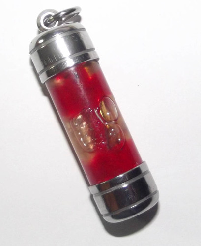 The takrut is immersed in metta oil and prai oils, and bound with sorcery using 'daay daeng akom', a red magical thread used to wrap amulets with incantations.